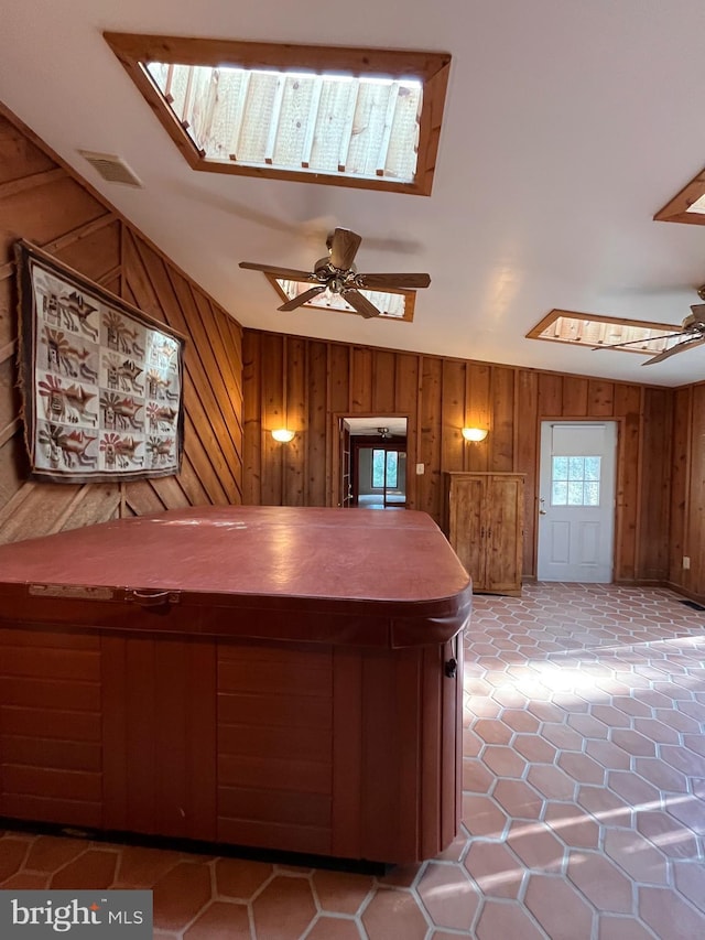 kitchen with ceiling fan and wood walls