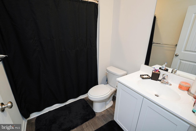 bathroom with hardwood / wood-style flooring, vanity, and toilet