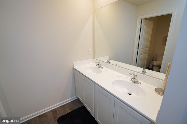 bathroom with vanity, hardwood / wood-style floors, and toilet