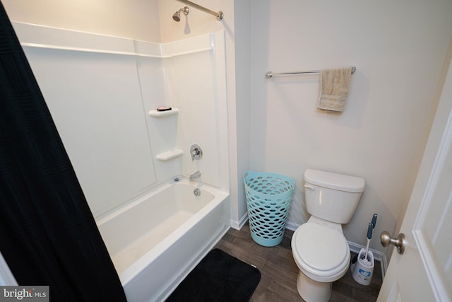 bathroom with shower / bathing tub combination, hardwood / wood-style flooring, and toilet