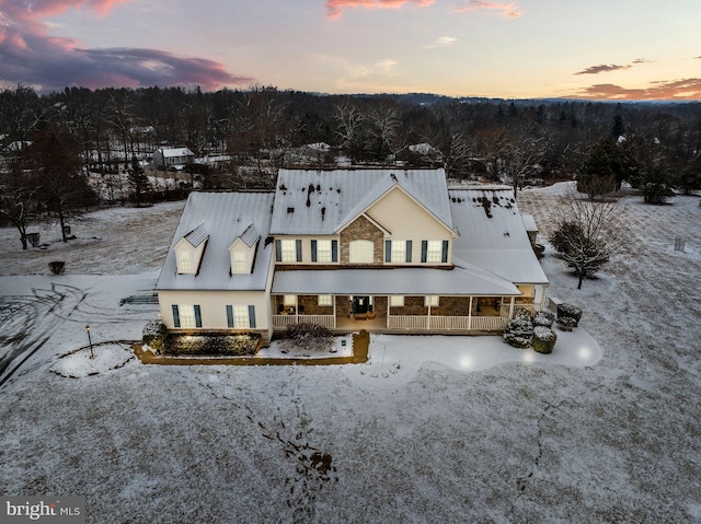 view of snow covered back of property