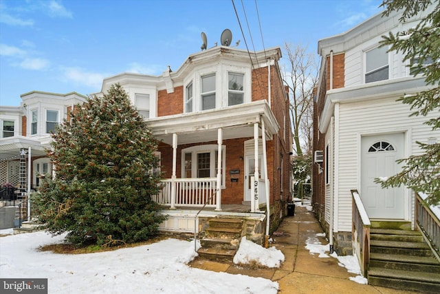 townhome / multi-family property featuring covered porch