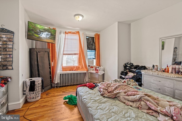 bedroom with radiator and light hardwood / wood-style flooring