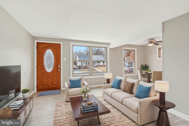 living area with light wood-style flooring and baseboards