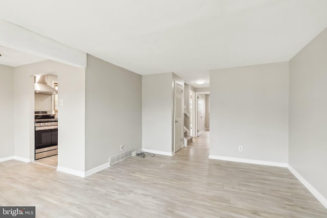 unfurnished room featuring light wood-style flooring, visible vents, and baseboards