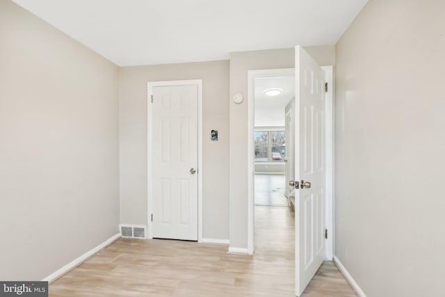 interior space with light wood finished floors, visible vents, and baseboards