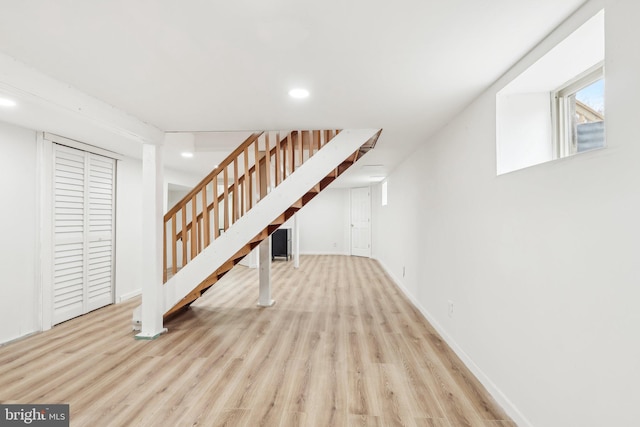 below grade area featuring stairs, baseboards, wood finished floors, and recessed lighting