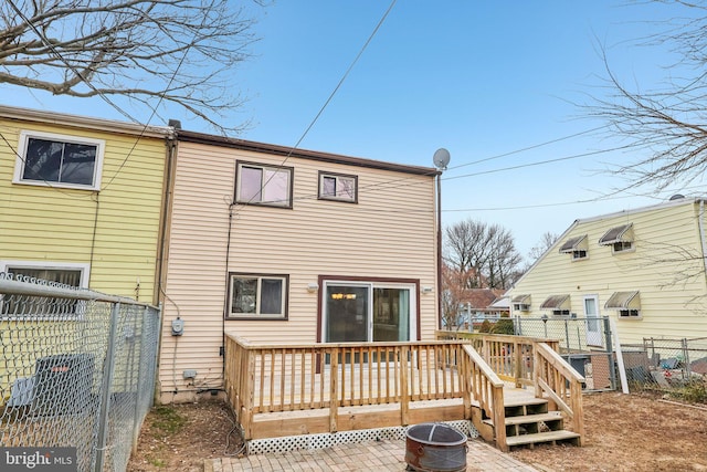 rear view of property featuring a gate, fence, and a deck