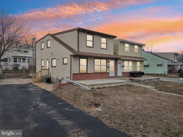 view of front of home with brick siding and fence