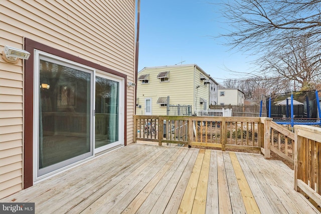 deck with a trampoline and fence