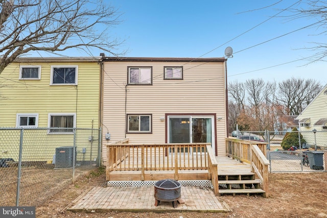 rear view of house with an outdoor fire pit, a fenced backyard, and a wooden deck