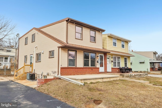 view of front of property with brick siding, cooling unit, and fence