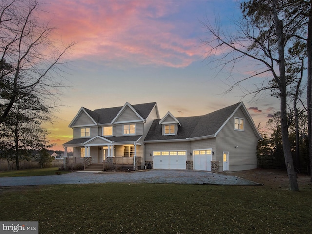 view of front of house with gravel driveway, stone siding, a front lawn, and a porch