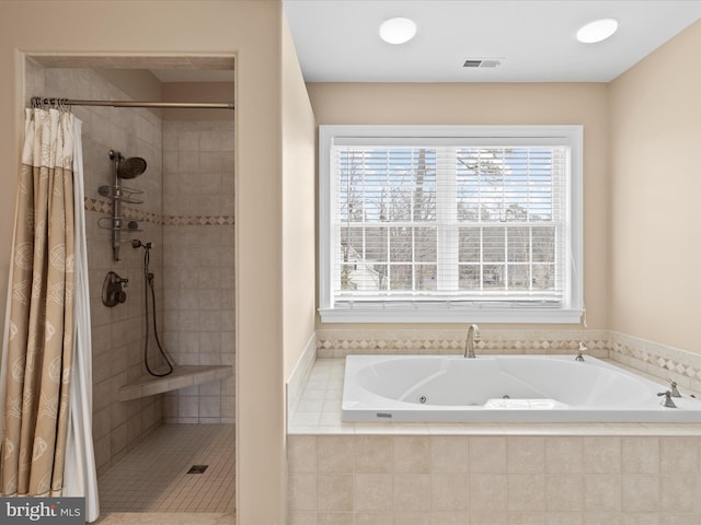 bathroom featuring a stall shower, a jetted tub, and visible vents