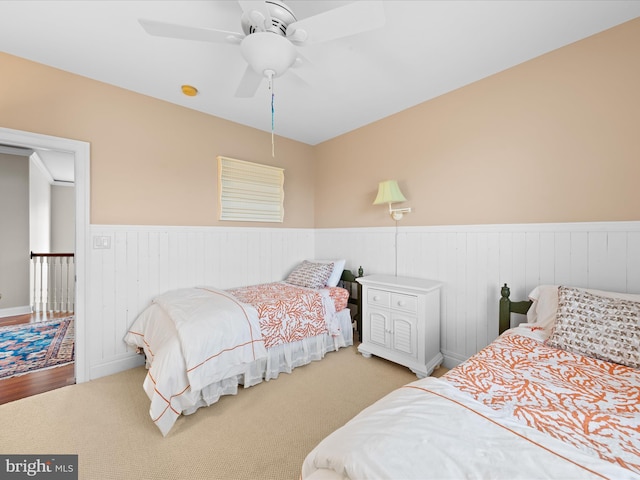 bedroom with wainscoting, ceiling fan, and carpet flooring