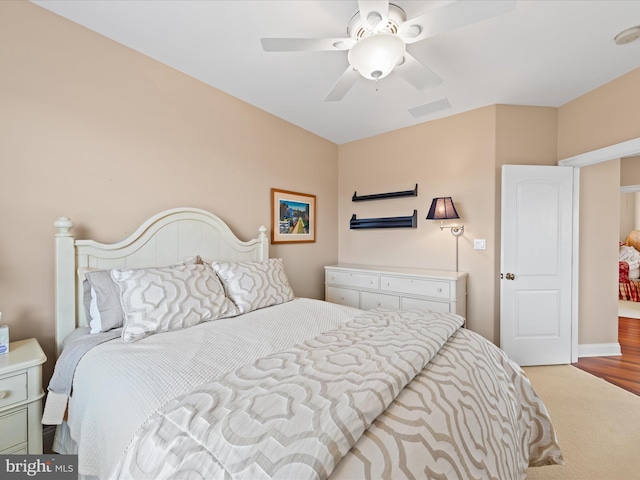 carpeted bedroom with visible vents and a ceiling fan