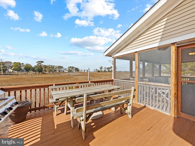 deck featuring a sunroom and outdoor dining space