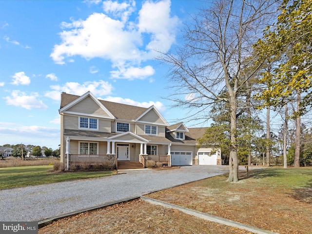 view of front of house with a garage, a front yard, gravel driveway, and a porch