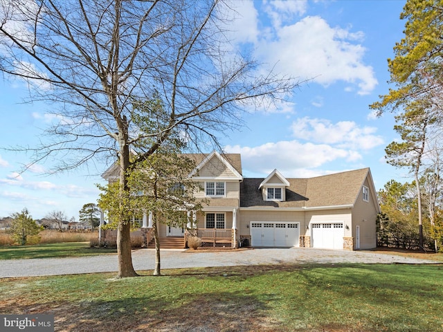 view of front of property with stone siding, an attached garage, driveway, and a front lawn