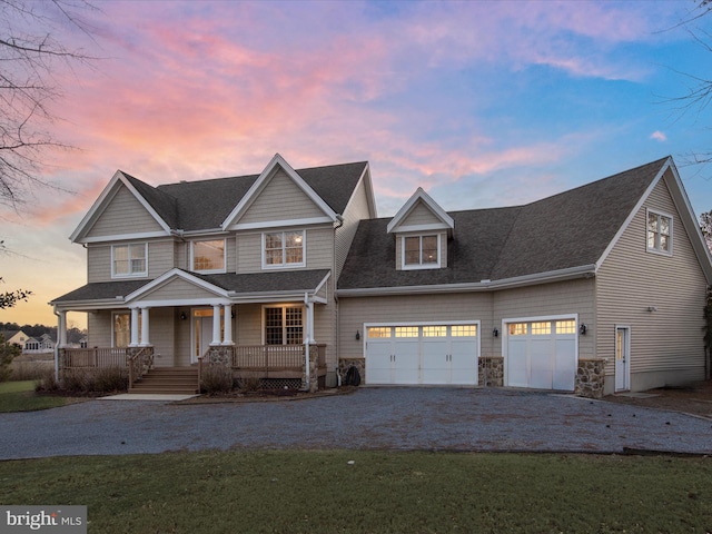 view of front of property featuring driveway, covered porch, a garage, and roof with shingles