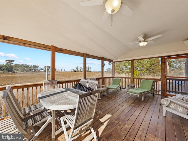 sunroom featuring vaulted ceiling, ceiling fan, a rural view, and a wealth of natural light