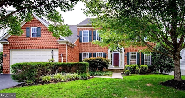 view of front facade with a garage, driveway, brick siding, and a front lawn