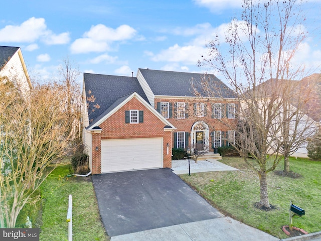 view of front of property featuring brick siding, aphalt driveway, a front yard, roof with shingles, and an attached garage