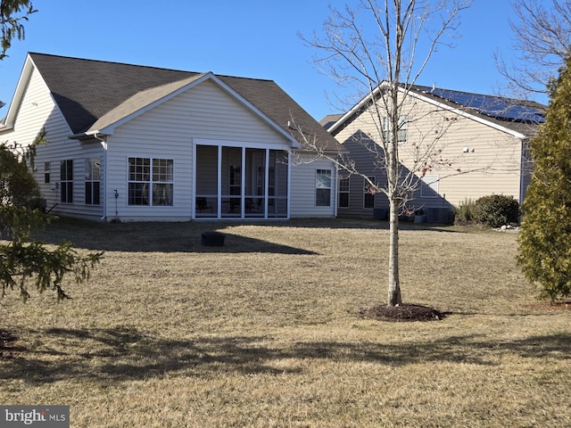 back of property with a lawn and a sunroom