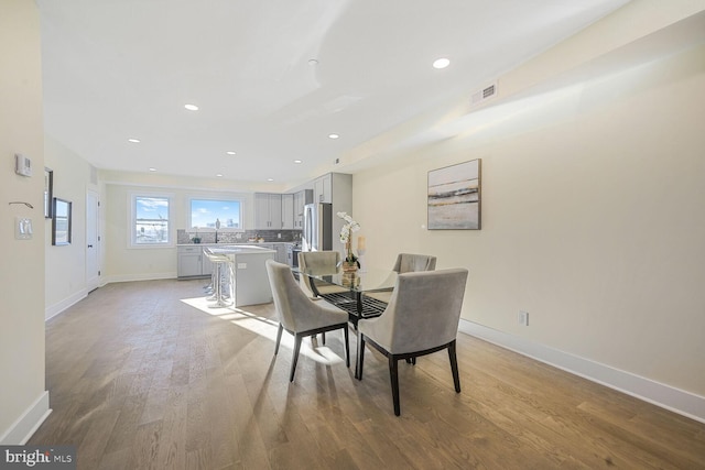 dining room featuring light wood-style floors, recessed lighting, visible vents, and baseboards