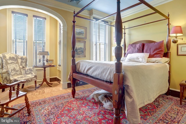 bedroom featuring baseboards, multiple windows, visible vents, and crown molding