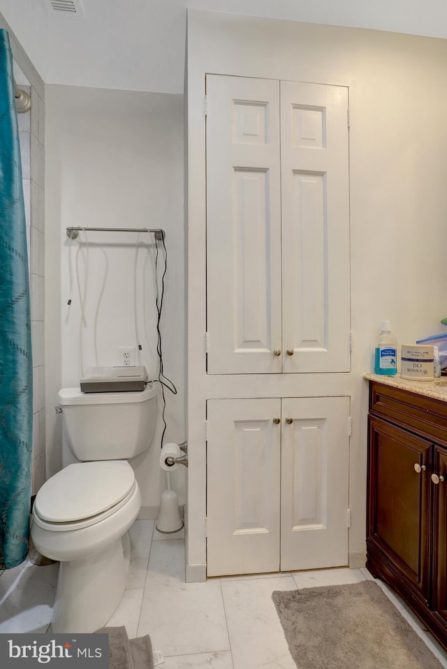 full bathroom featuring vanity, marble finish floor, curtained shower, toilet, and a closet