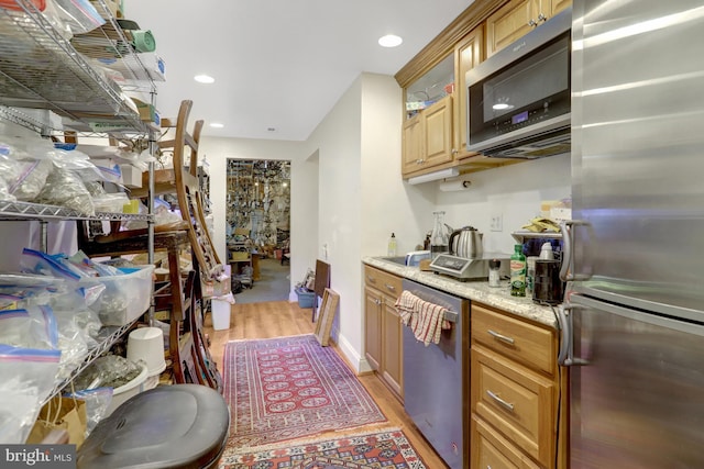 kitchen featuring light wood-type flooring, brown cabinets, stainless steel appliances, and recessed lighting