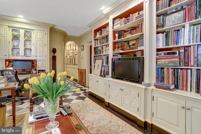 sitting room with dark floors, ornamental molding, and recessed lighting