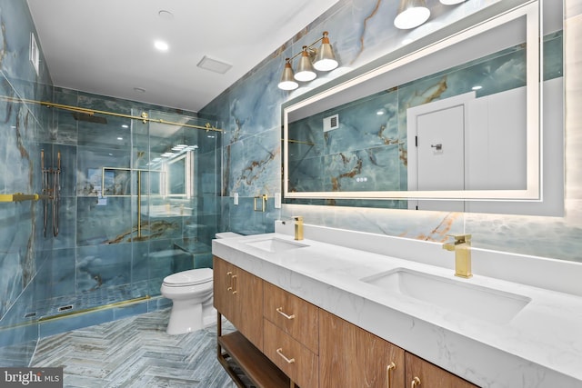 full bathroom featuring toilet, double vanity, a sink, and tile walls