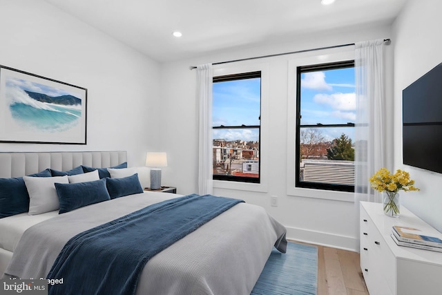 bedroom with light wood-style floors, recessed lighting, and baseboards