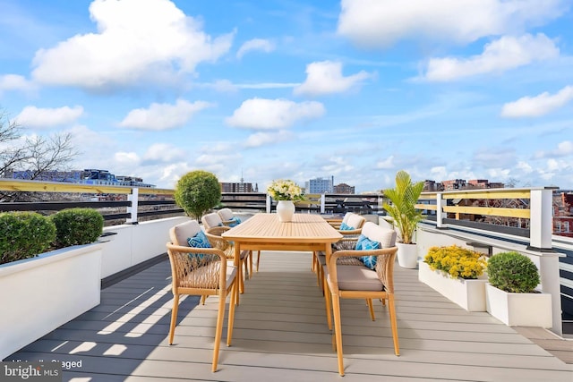 wooden terrace featuring a view of city and outdoor dining area