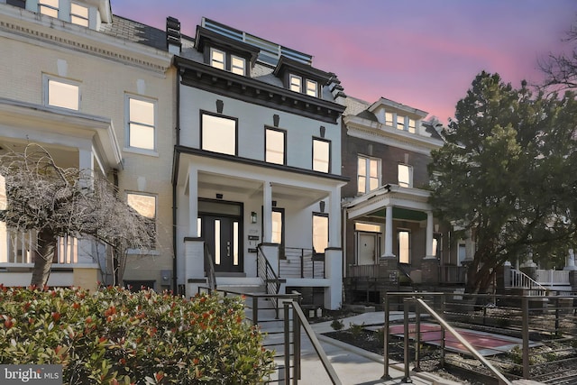 view of front of property featuring mansard roof and brick siding