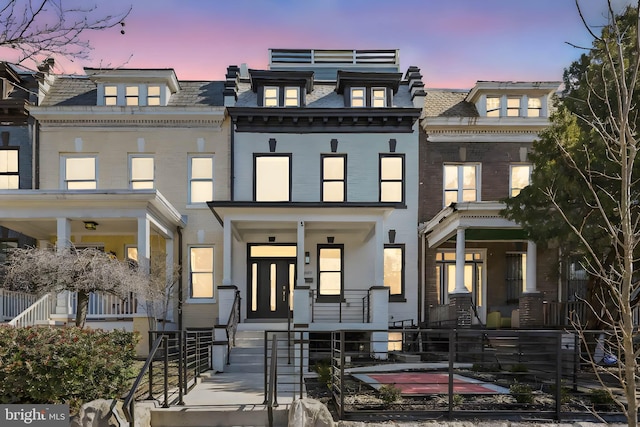 view of front facade featuring mansard roof and brick siding