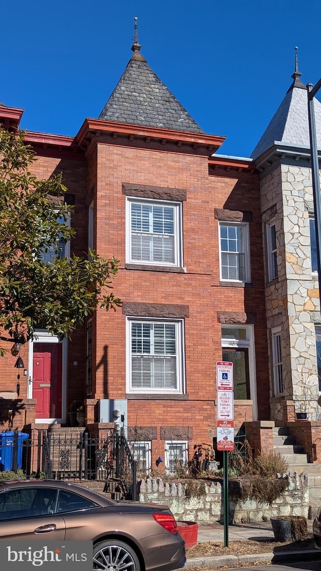 view of front of house with brick siding and a high end roof