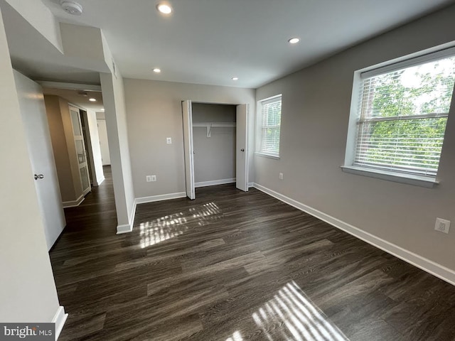 unfurnished bedroom featuring dark hardwood / wood-style flooring and a closet