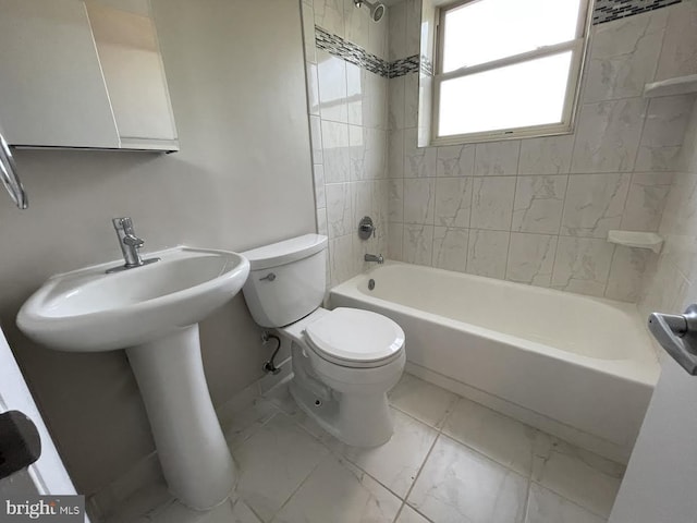 bathroom with tiled shower / bath and toilet