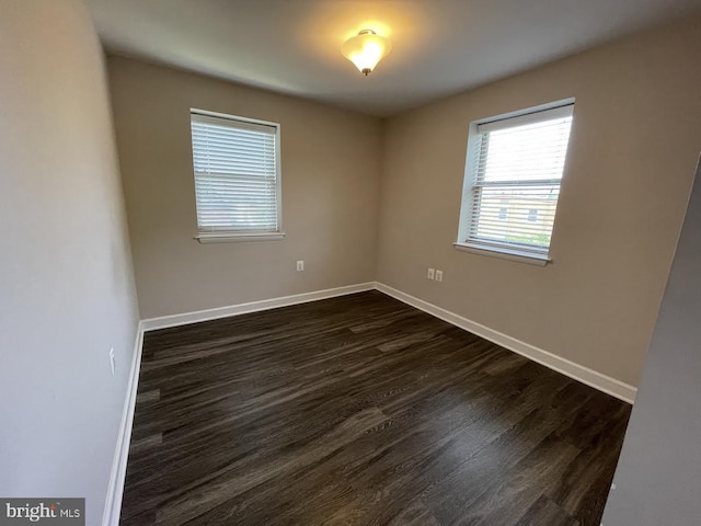 spare room with dark hardwood / wood-style flooring