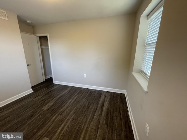 unfurnished bedroom with a closet and dark hardwood / wood-style floors