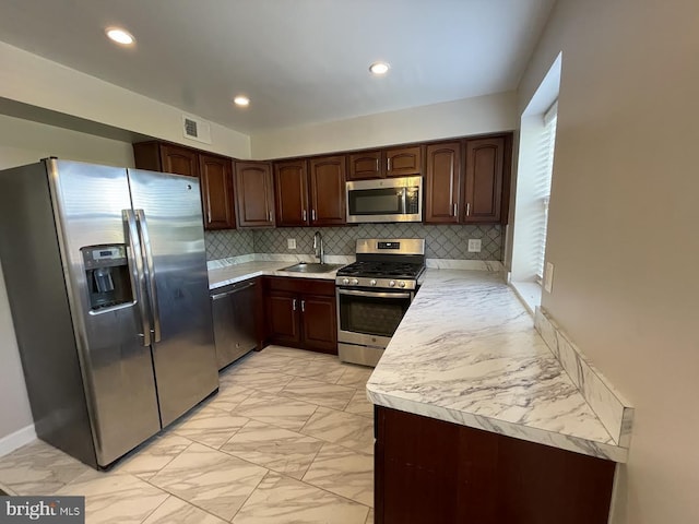 kitchen featuring tasteful backsplash, stainless steel appliances, sink, and dark brown cabinets