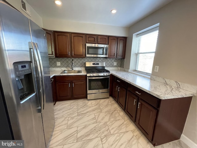 kitchen featuring tasteful backsplash, sink, stainless steel appliances, and dark brown cabinetry