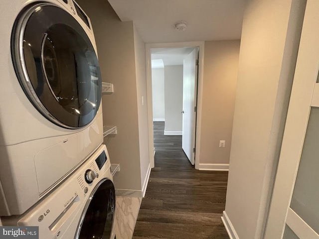 laundry room with stacked washer and dryer and dark wood-type flooring