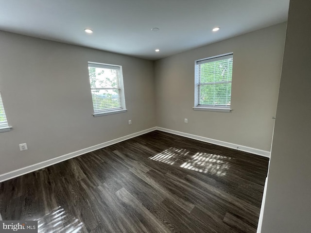 unfurnished room featuring dark hardwood / wood-style flooring and a healthy amount of sunlight