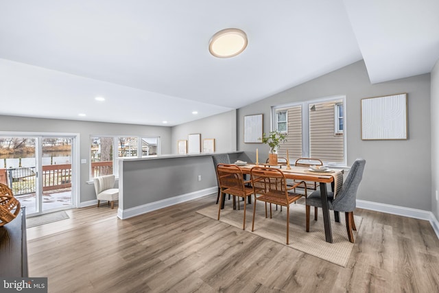 dining area featuring lofted ceiling and light wood-type flooring