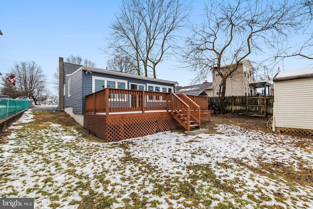 snow covered property featuring a wooden deck