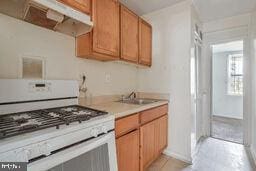 kitchen featuring white gas range and sink